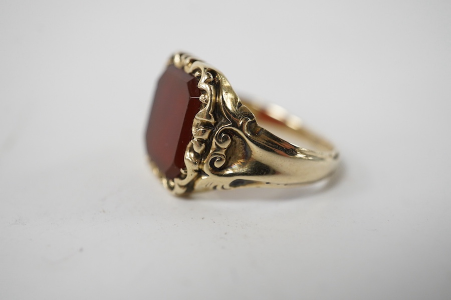 A carved yellow metal and carnelian set signet ring, size I/J, gross weight 5.1 grams. Condition - fair